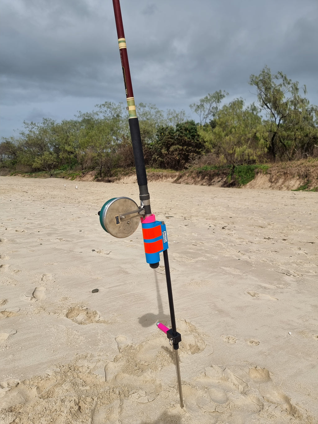 Stainless steel and fibreglass fishing rod holder with rod and alvey reel on beach