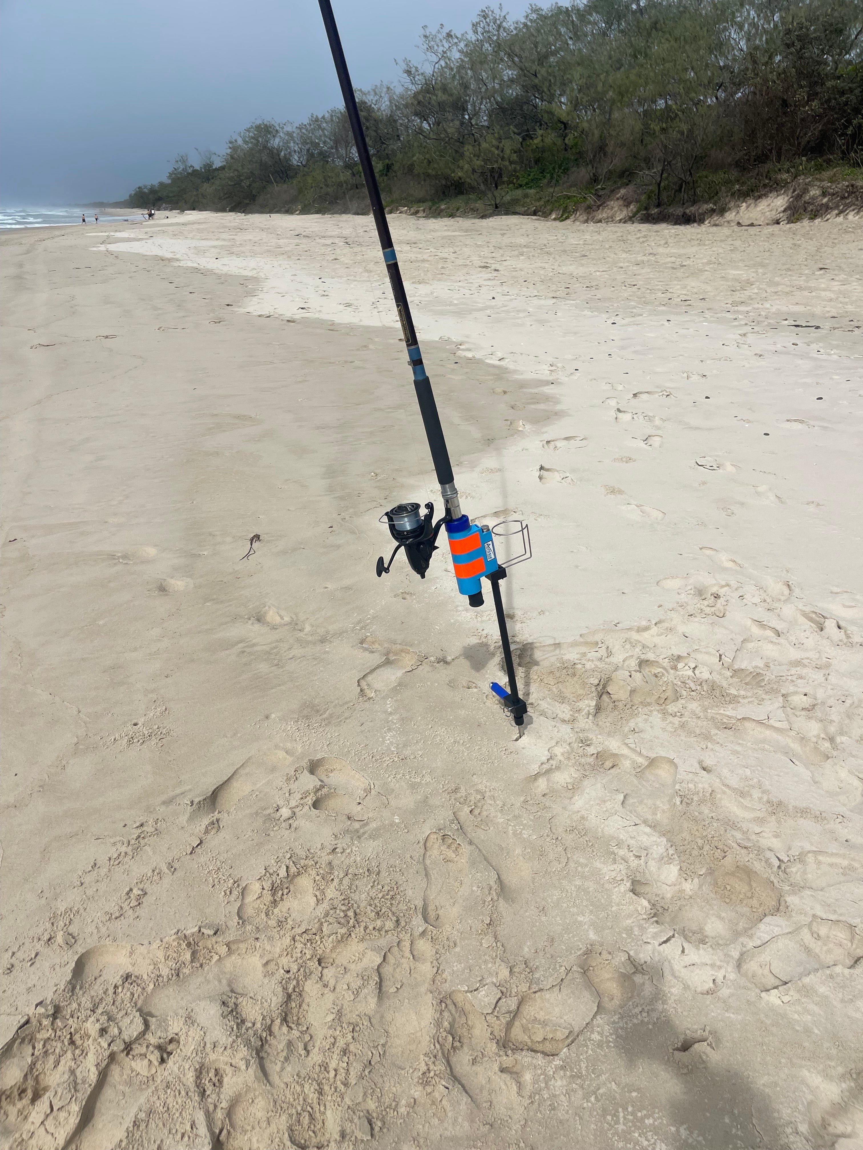 Fishing rod holder with drinks holder on sandy beach