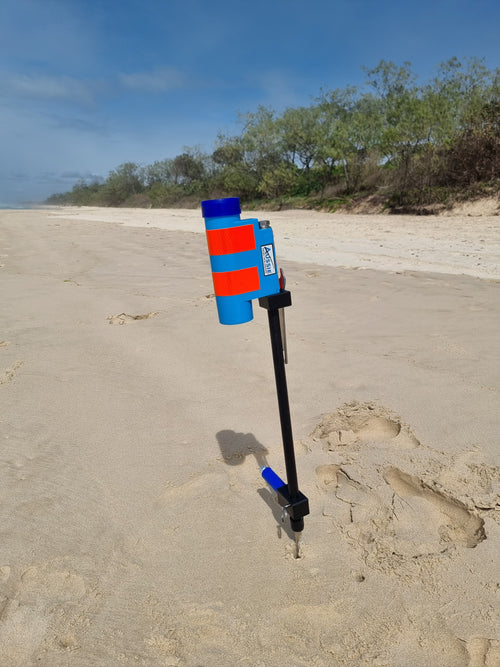 Fibreglass fishing rod holder that is blue in colour in beach with blue foot peg