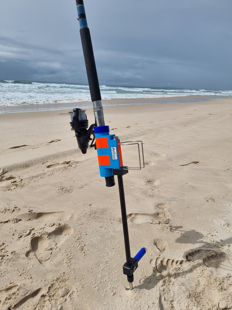 Fishing rod and reel with sand spike and cup holder on sandy beach