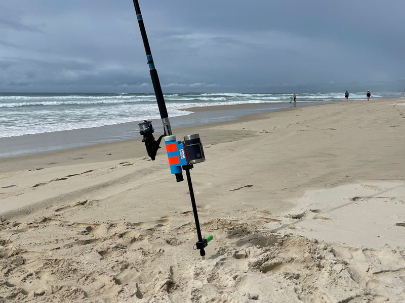Fibreglass and stainless steel fishing rod holder with drinks holder on beach
