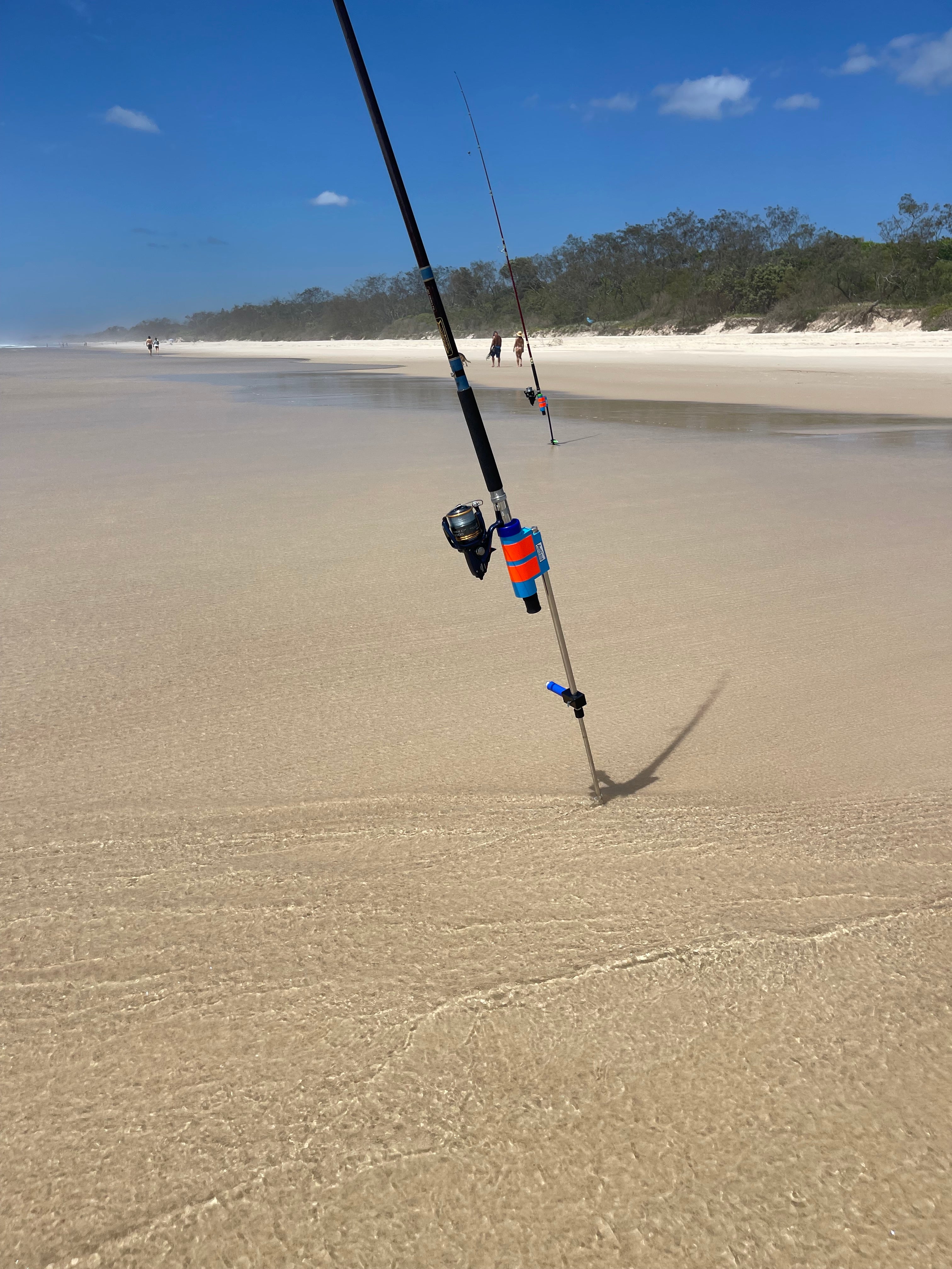 Fishing rod and reel in stainless steel rod holder in surf