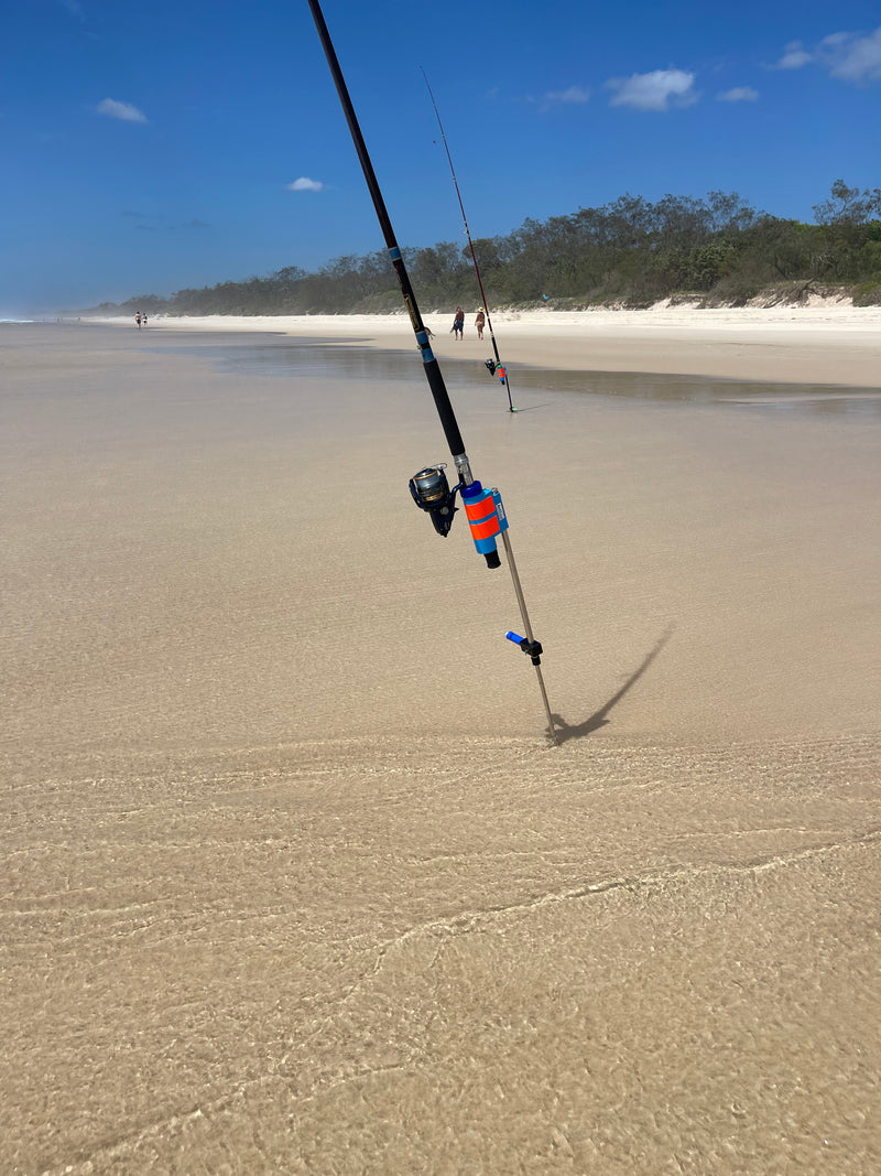 Fishing rod and reel in stainless steel rod holder in surf
