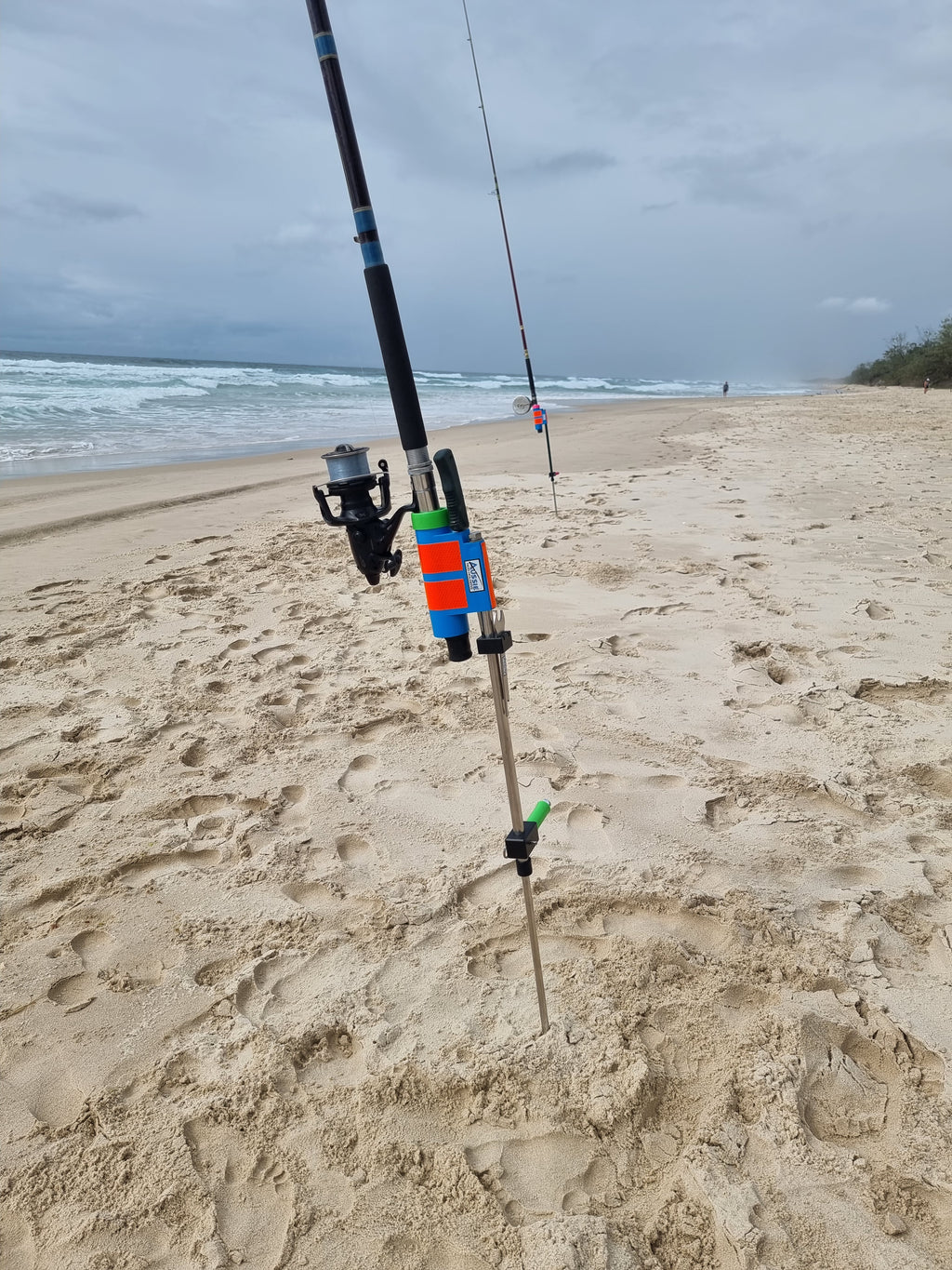 Rod and baitrunner in stainless steel rod holder with fishing knife on beach