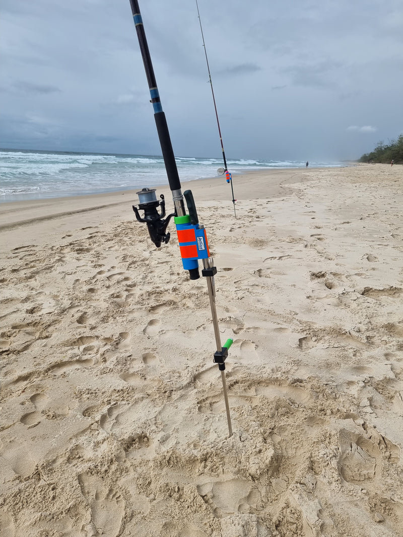 Rod and baitrunner in stainless steel rod holder with fishing knife on beach