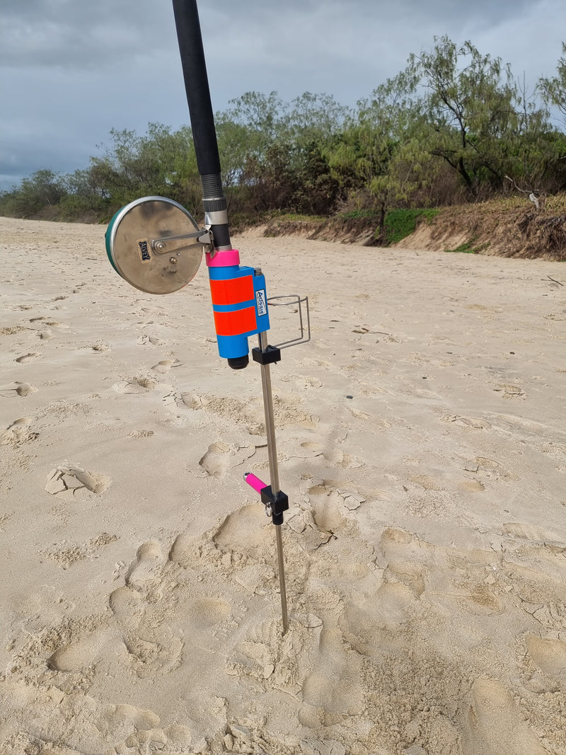 Colorful fishing rod holder on a sandy beach with trees in the background