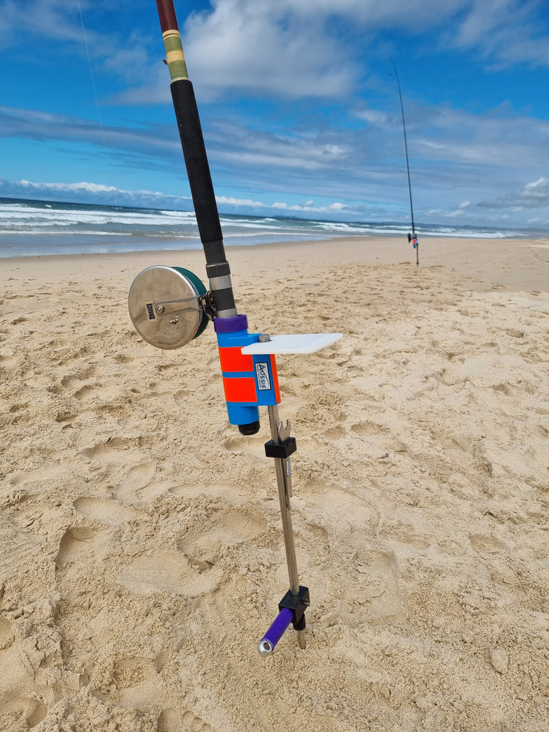Fishing rod with alvey reel in stainless steel rod holder with bait board at beach